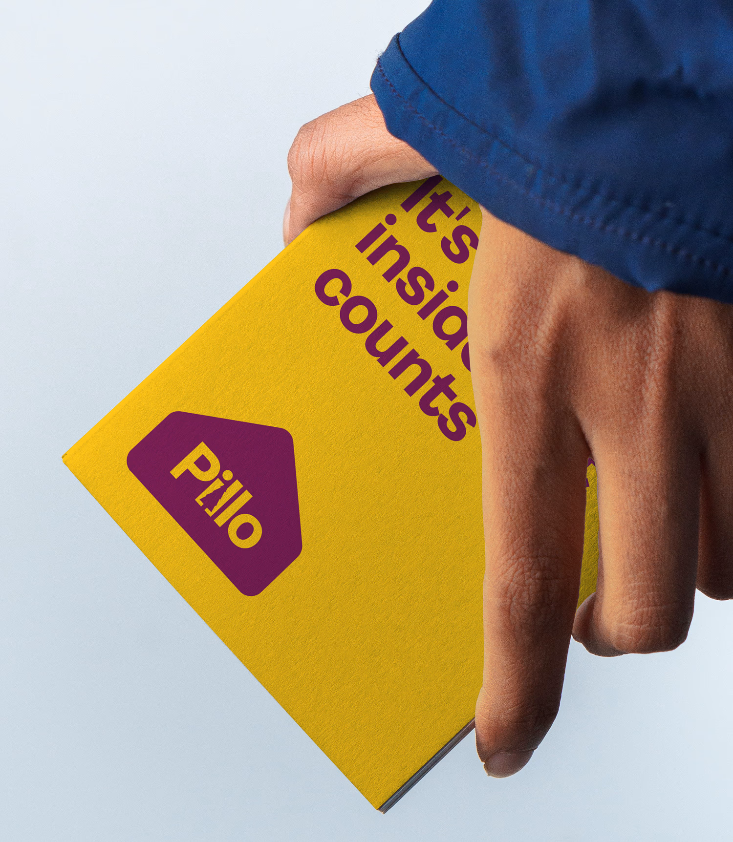 Hand holding Pillo branded wood fibre insulation board with 'It's inside that counts' text